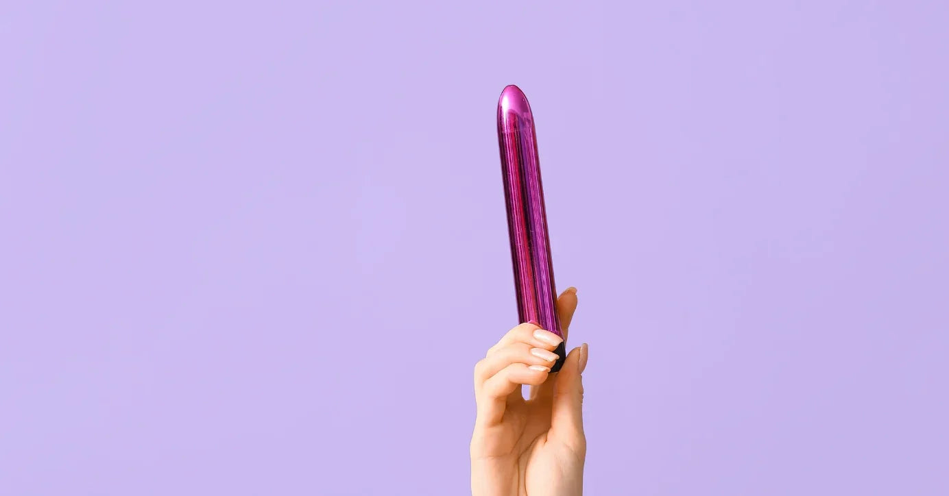 Hand hält lila Vibrator, Erotikspielzeug vor lila Hintergrund, Diskretes Sextoy-Foto