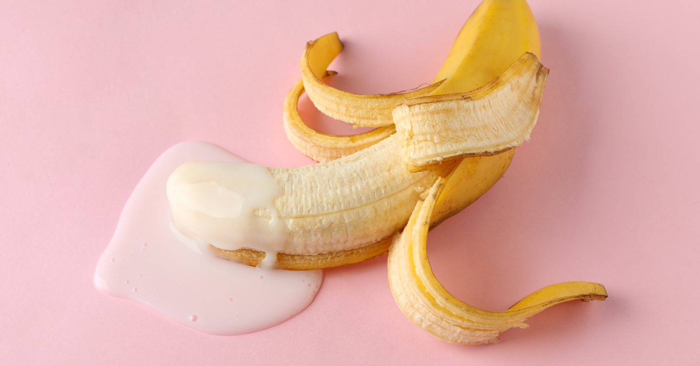 Banane mit Schale und glitschigem Gel auf rosa Hintergrund, Symbol für Erotikprodukte