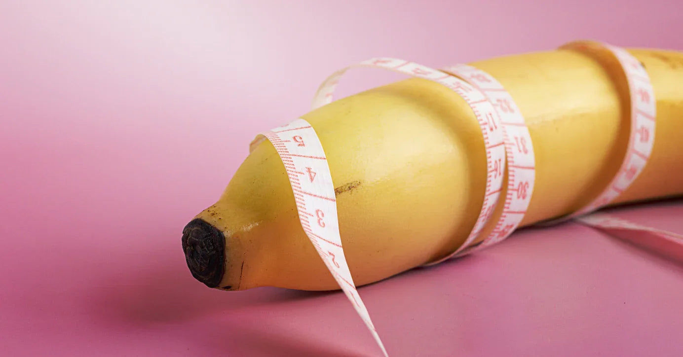 Banane mit MaĂband auf rosa Hintergrund, Symbol fĂŒr Liebesleben und Erotikprodukte