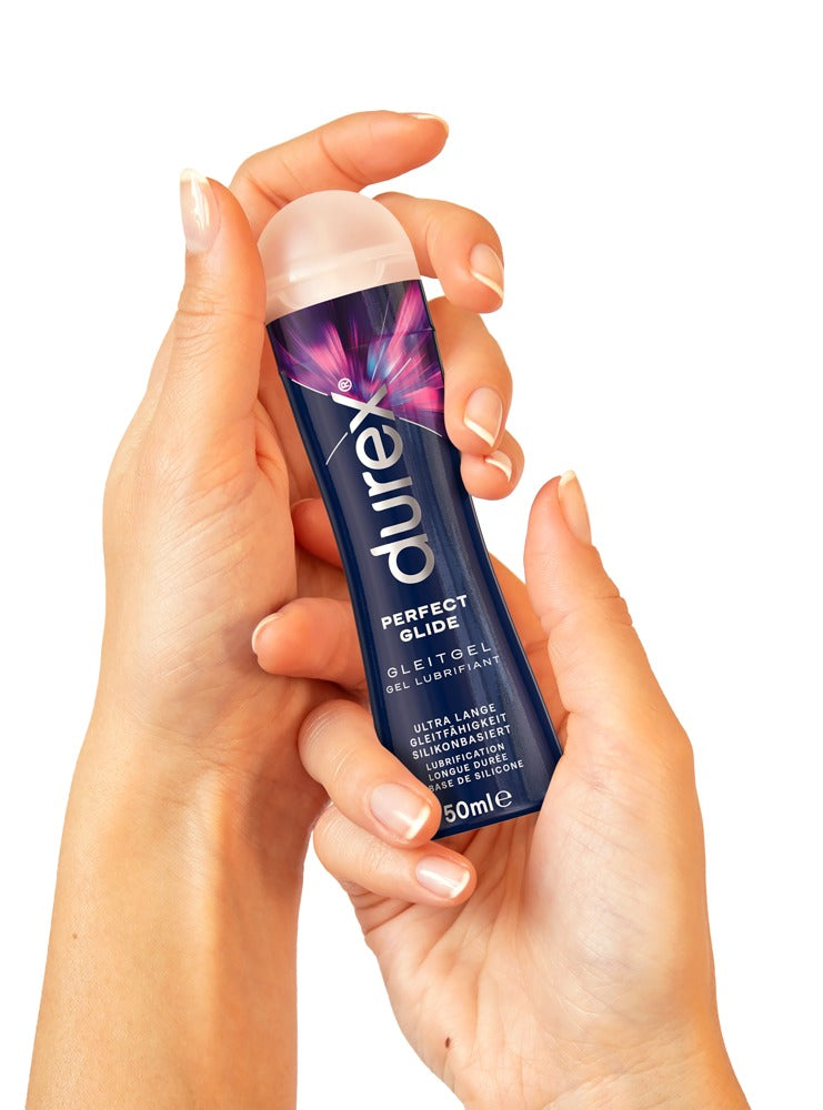 Nahaufnahme einer Hand hält Durex Gleitgel Perfect Glide, Silikonbasis, 50ml, weißer Hintergrund