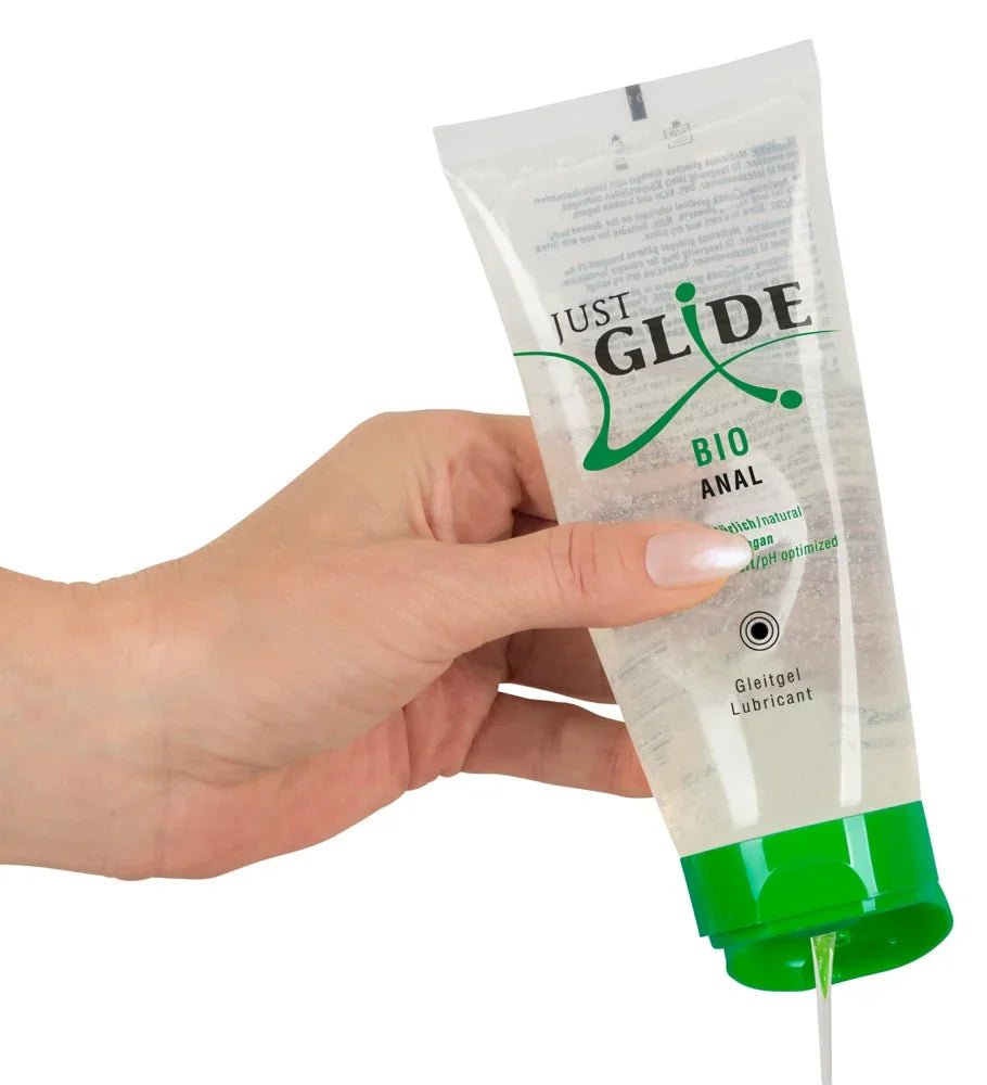 Hand hält Tube Just Glide Bio Anal Gleitgel, durchsichtig, veganes Gleitmittel, grüne Kappe