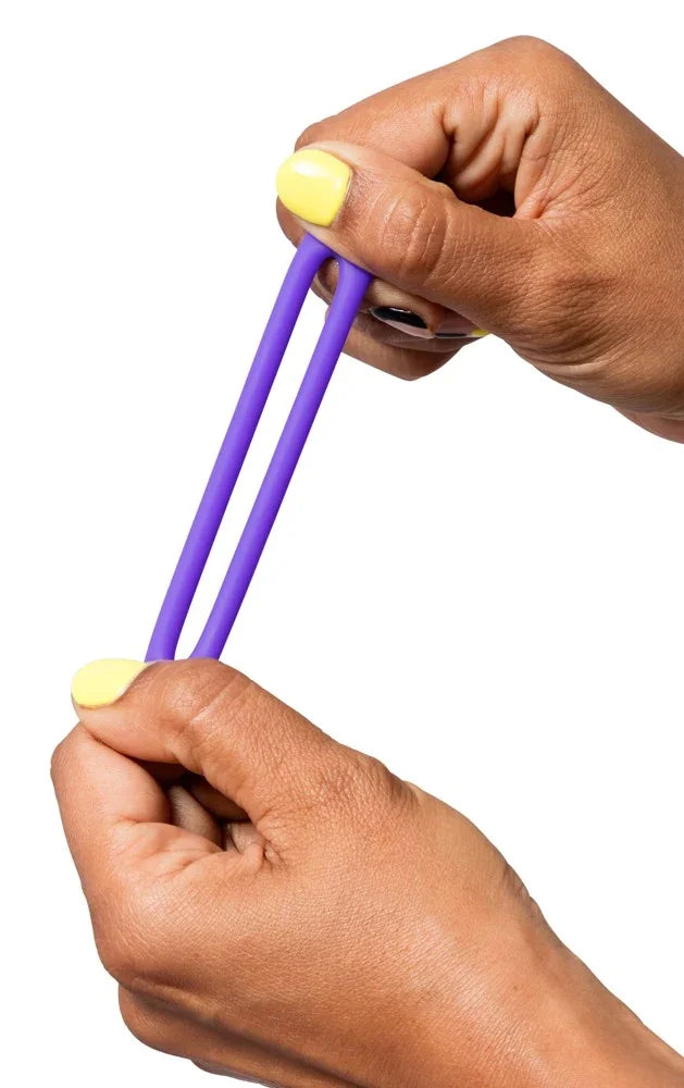 Lila Vibrator mit gelben Nägeln gehalten – intim für das Liebesleben