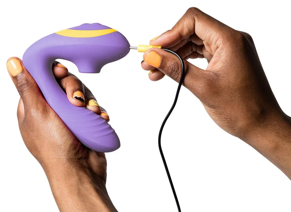 Lila Vibrator mit gelber Ladebuchse in Händen, Nahaufnahme, Sexspielzeug für Erwachsene