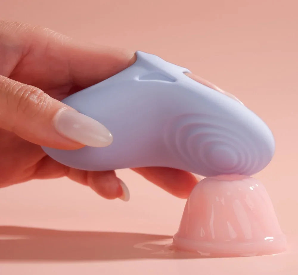 Lila Vibrator mit wellenförmiger Oberfläche und rosa Gleitgel für intime Momente