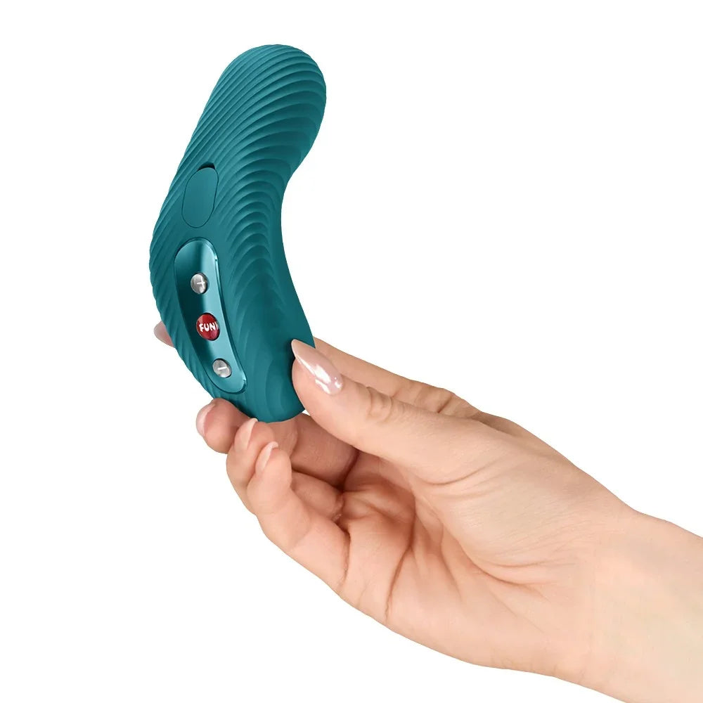 Grüner Vibrator mit Wellenstruktur und Bedienelementen in der Hand