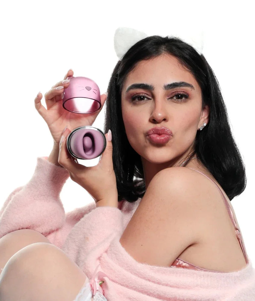 Frau mit Katzenohren hält rosa Vibrator mit Katzenmotiv – Intimspielzeug für Erwachsene
