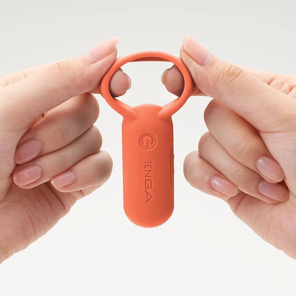 TENGA Vibrator in Orange, gehalten von Händen – ideal für das Liebesleben