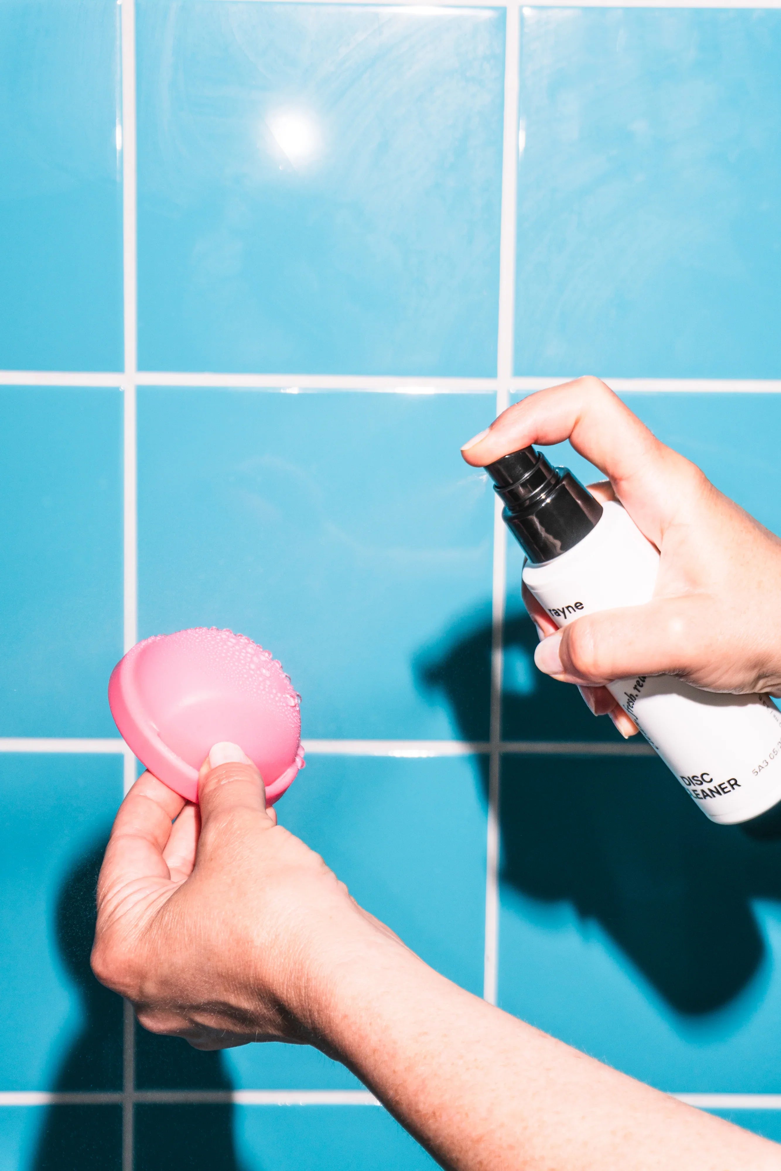 Reinigung von Sextoy mit Disc Cleaner Spray vor blauer Fliese