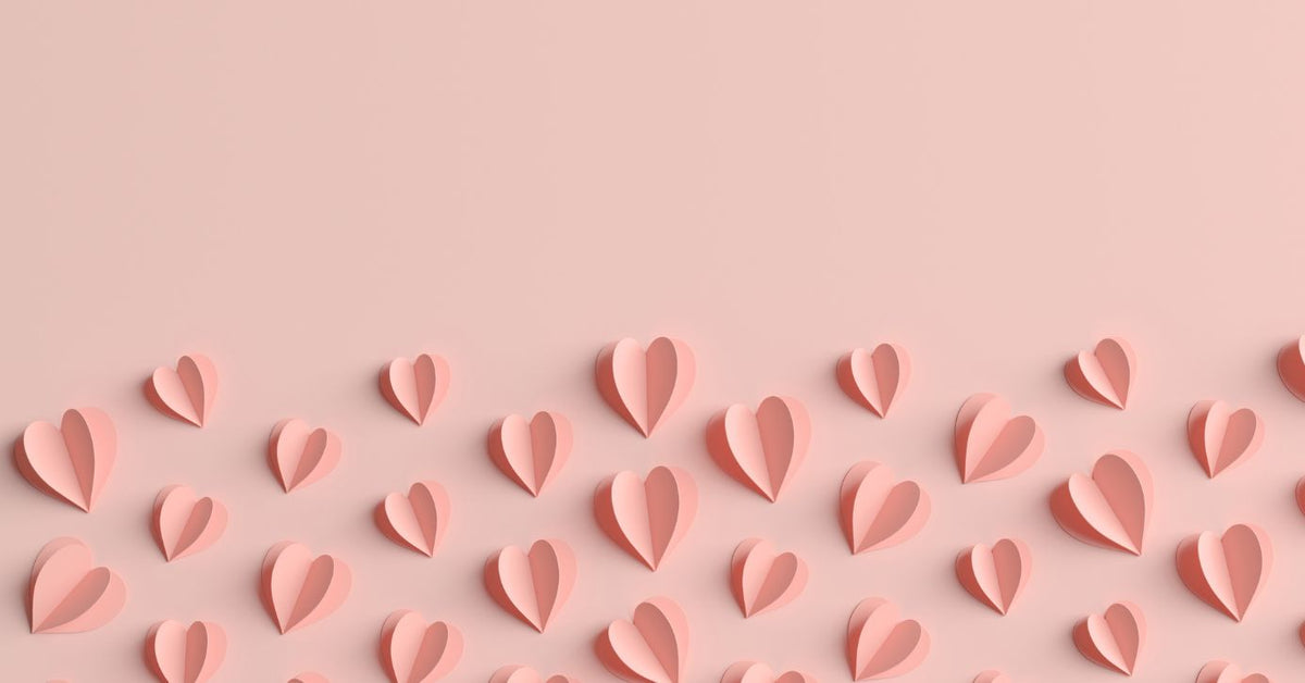 Zartrosa Papierherzen auf pastellfarbenem Hintergrund, Symbol für Liebe, Erotik und Intimität