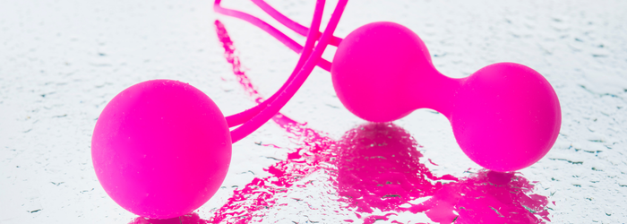 Pinkes Liebesspielzeug, Silikonkugeln auf nasser Oberfläche, Erotik Zubehör