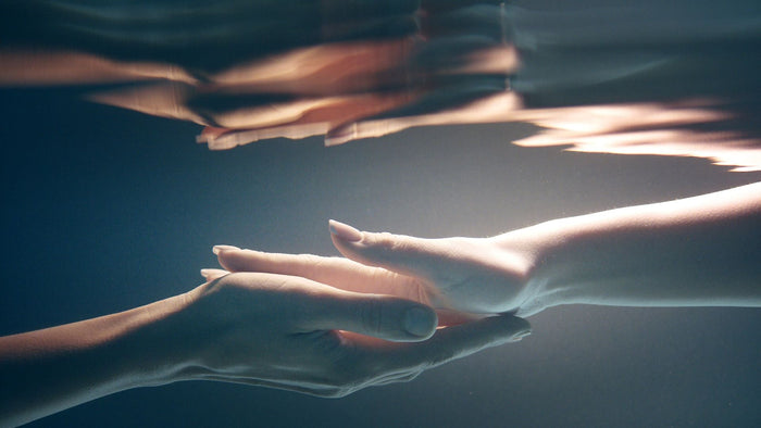 Zwei sich zärtlich berührende Hände unter Wasser, Sinnlichkeit, Erotik, intime Nähe