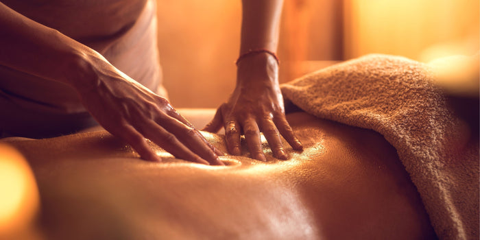Sinnliche Massage mit Gleitgel, entspannte Atmosphäre, Nahaufnahme Hände auf Haut