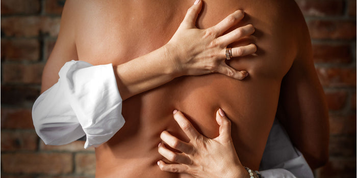 Nahaufnahme von nacktem Rücken mit Händen, die für erotische Intimität und Leidenschaft stehen