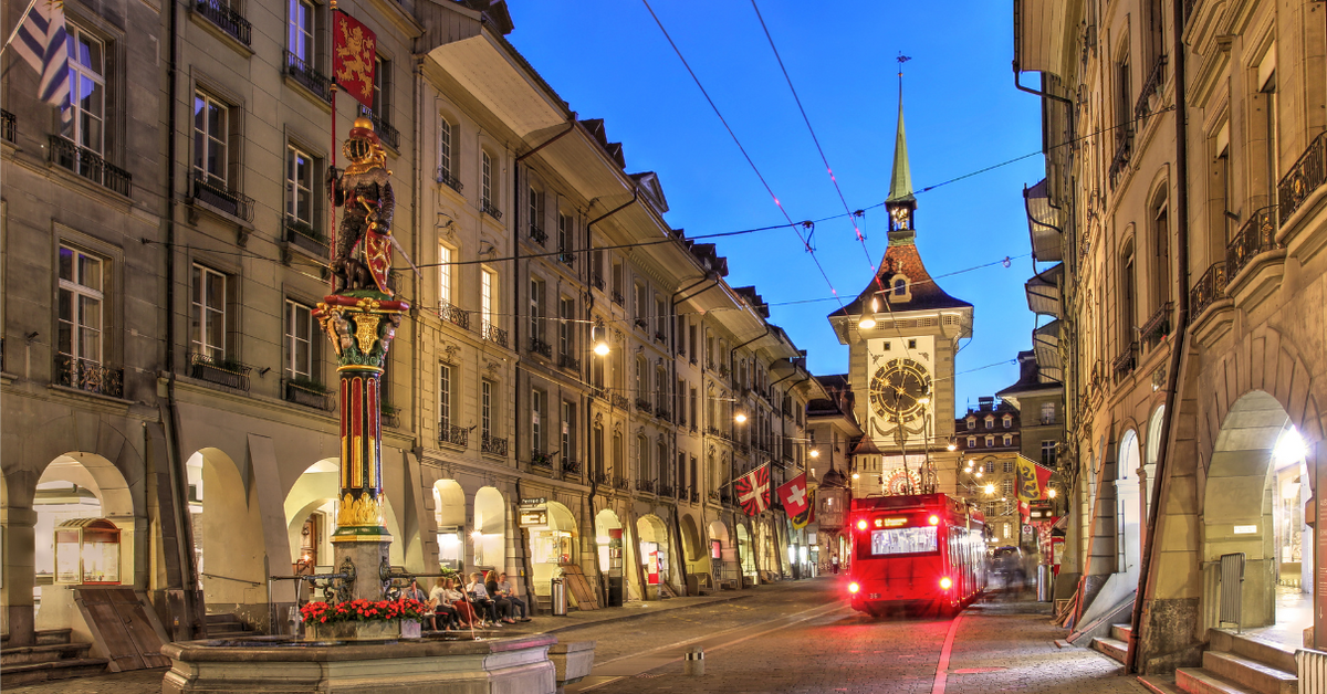 Altstadt von Bern bei Abenddämmerung mit Bus, Zytglogge-Turm und historischen Gebäuden