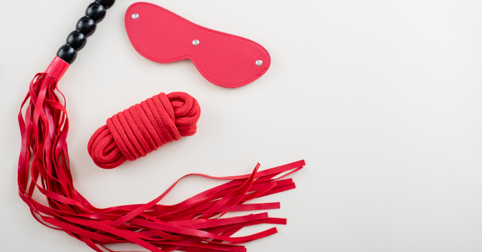 Erotik Set mit Augenmaske, Fessel-Seil und Peitsche in Rot auf weißem Hintergrund