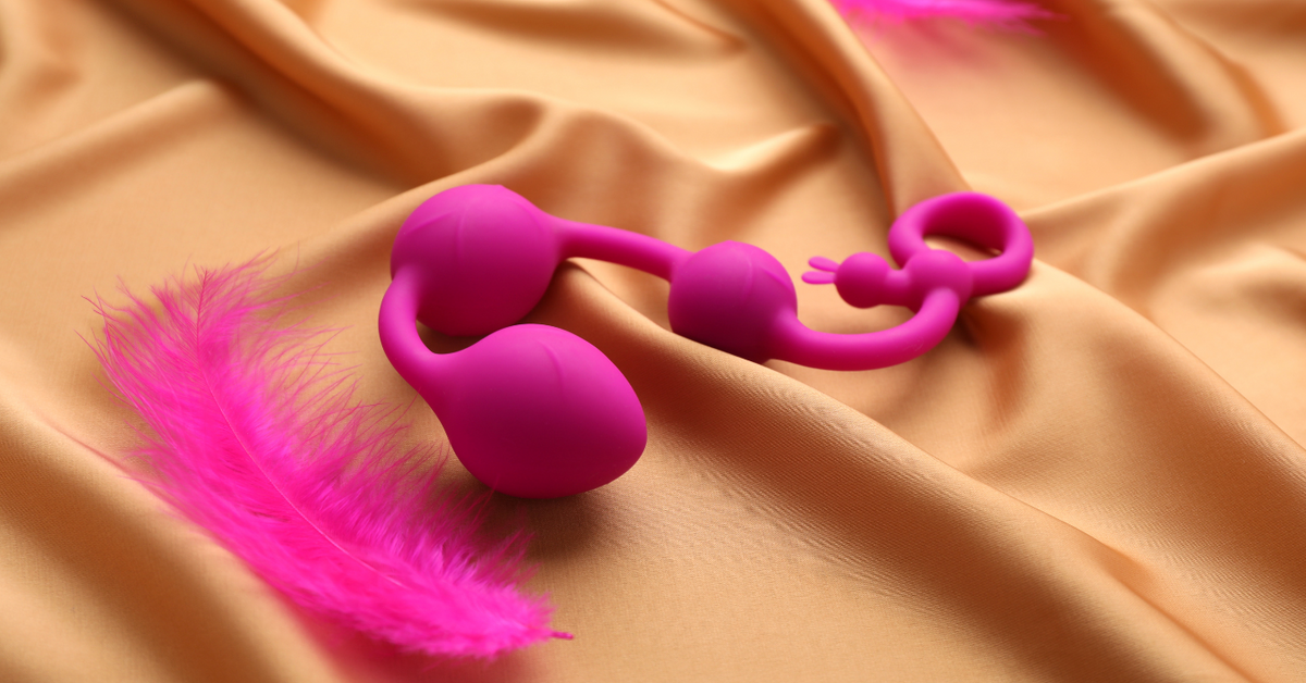 Pinkes Liebesspielzeug und Feder auf Satin, Erotikartikel für Erwachsene, sinnliches Zubehör