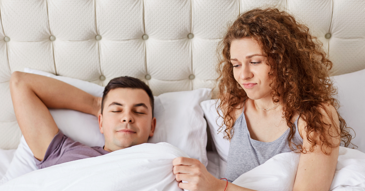 Frau und Mann im Bett, Frau wirkt unzufrieden, Paar mit Liebesleben Problemen
