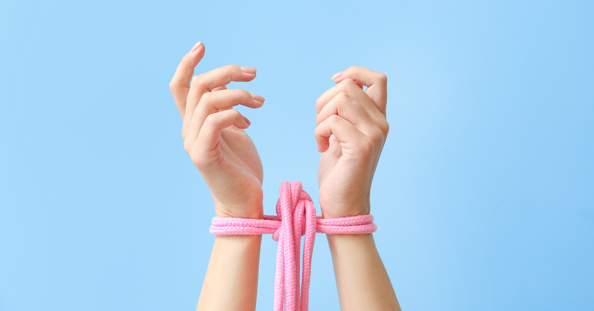Zwei Hände mit rosa Bondage-Seil auf hellblauem Hintergrund, Erotikspielzeug Accessoire