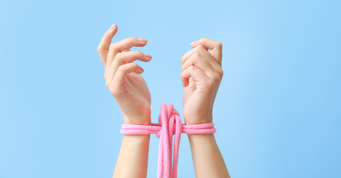 Zwei Hände mit rosa Bondage-Seil auf hellblauem Hintergrund, Erotikspielzeug Accessoire