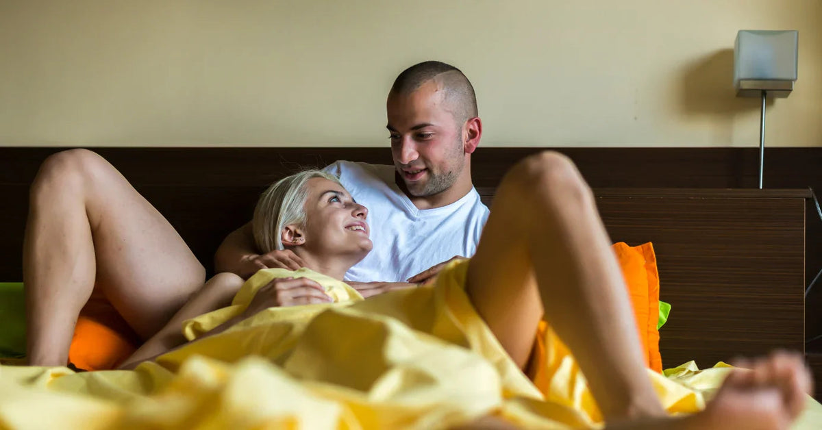 Lächelndes Paar im Bett, Zärtlichkeit und Nähe, intime Schlafzimmer-Atmosphäre