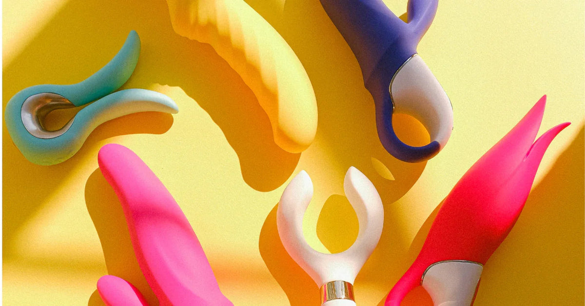 Bunte Vibratoren und Massagestab auf gelbem Hintergrund, Erotikspielzeug für Paare und Singles