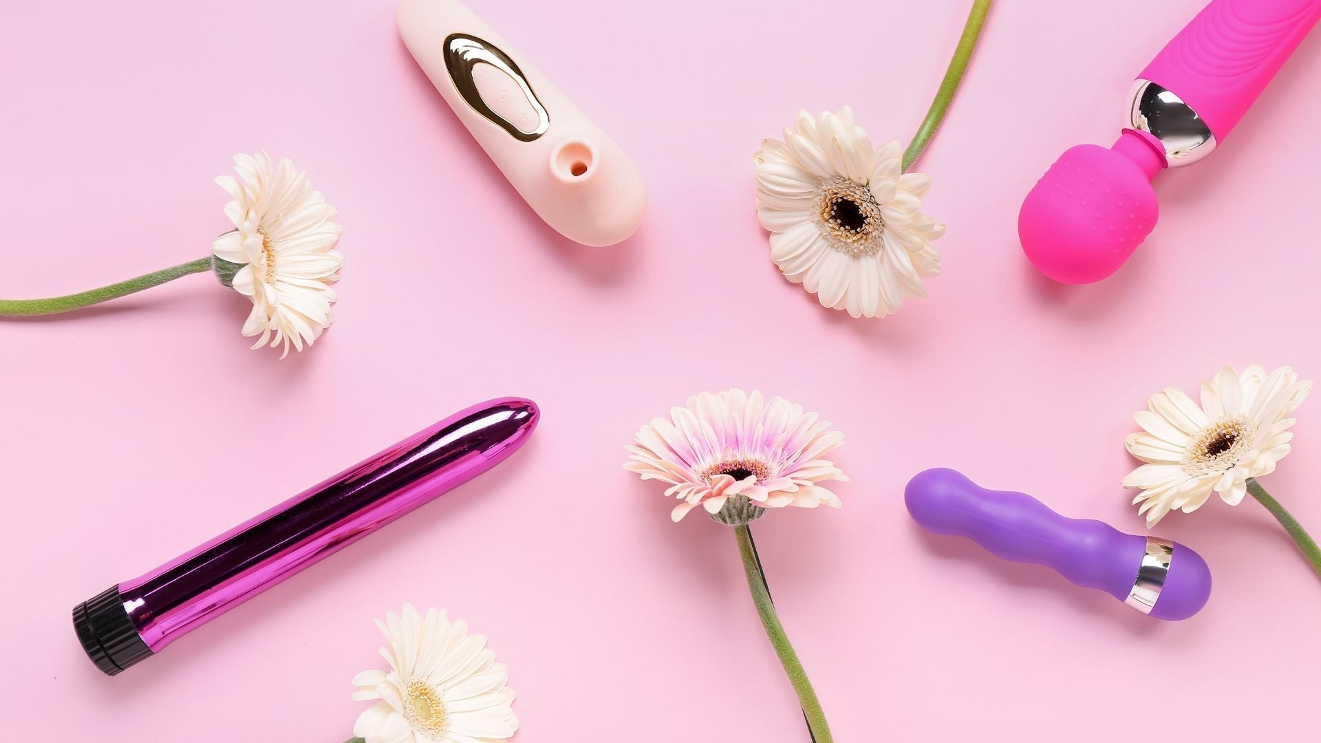 Verschiedene Vibratoren in Pink und Lila auf rosa Hintergrund mit Blumen, Erotikspielzeug