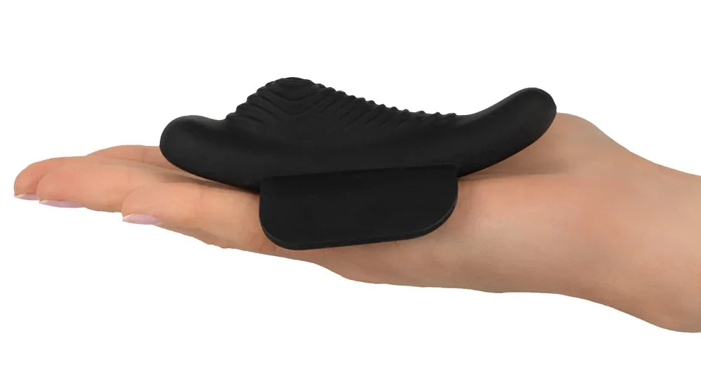 Schwarzer Vibrator aus Silikon mit strukturierter Oberfläche auf einer Hand liegend